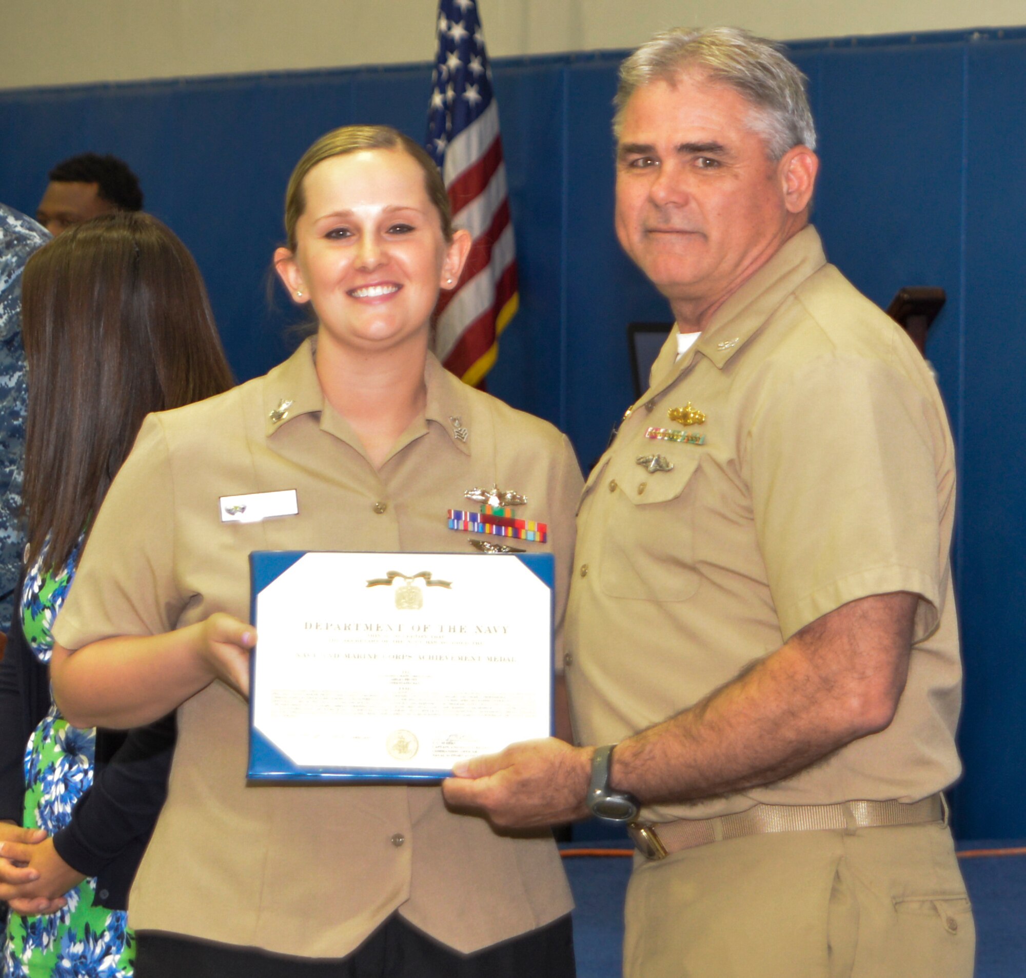 Captain Timothy Sparks, Joint Base Charleston deputy commander, presents the Navy Achievement Medal to MM1 Ashley Pruitt, Nuclear Power Training Unit, during the Sexual Assault Prevention and Response Program luncheon April 30, 2015 at Joint Base Charleston – Weapons Station, S.C. The Navy Achievement Medal was presented to Pruitt for her dedicated to the SAPR program through volunteer hours, donations raised, victim response and education and awareness.  (U.S. Air Force photo/Seamus O’Boyle)