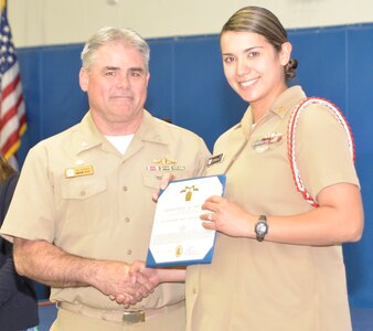 Captain Timothy Sparks, Joint Base Charleston deputy commander, presents the Navy Achievement Medal to MMC Erica Dopson, Naval Nuclear Power Training Command, during the Sexual Assault Prevention and Response Program luncheon April 30, 2015 at Joint Base Charleston – Weapons Station, S.C. The Navy Achievement Medals were presented to Dopson for her dedicated to the SAPR program through volunteer hours, donations raised, victim response and education and awareness. (U.S. Air Force photo/Seamus O’Boyle)