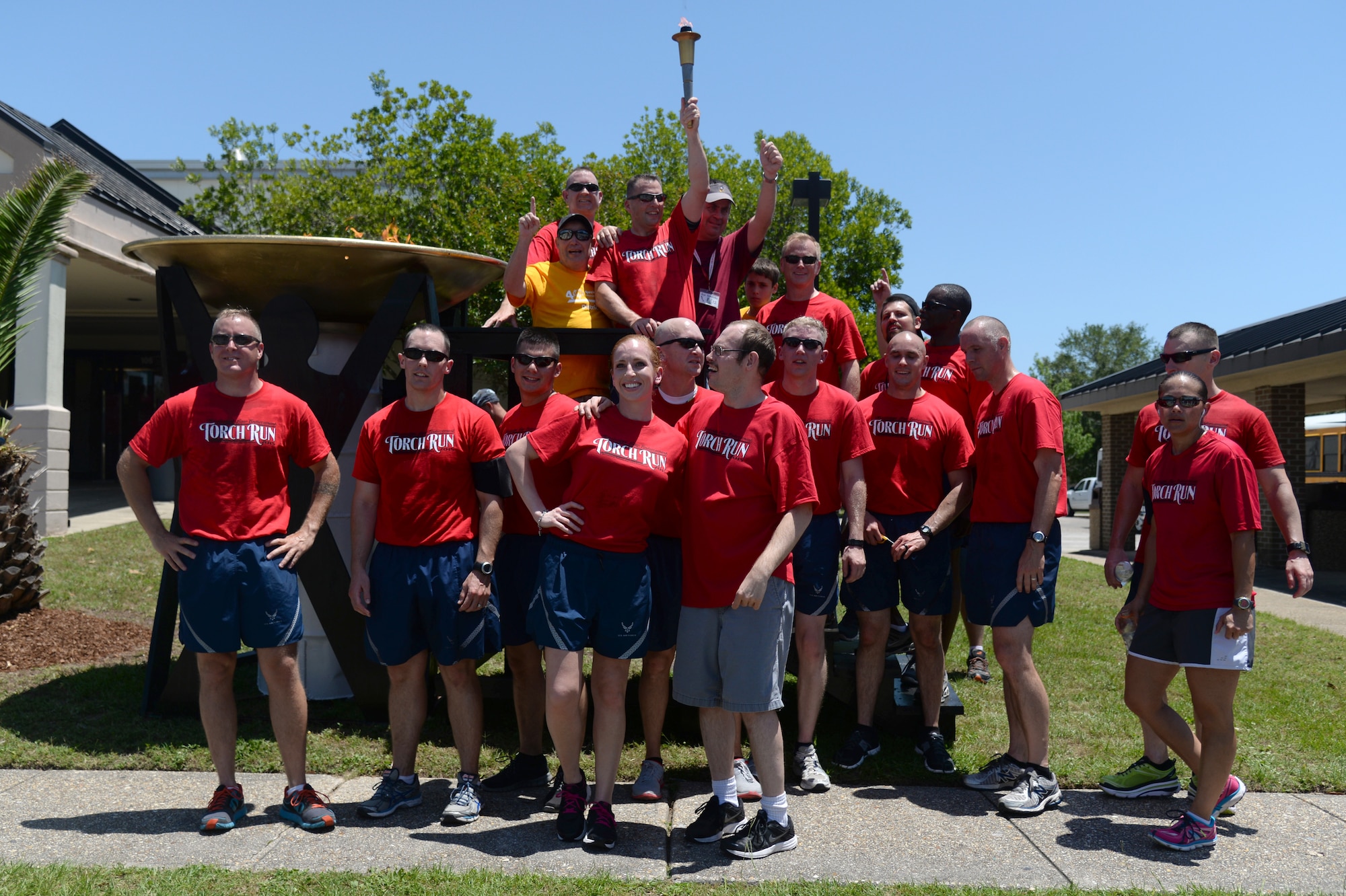 Airmen from the 81st Security Forces Squadron, 81st Training Wing leadership and Special Olympics athletes celebrate the end of the 2015 Law Enforcement Torch Run for Special Olympics, May 8, 2015, Keesler Air Force Base, Miss. Law enforcement officers from across Mississippi participated in the annual event to escort the Special Olympics Flame of Hope to the opening ceremonies. (U.S. Air Force photo by Senior Airman Holly Mansfield)
