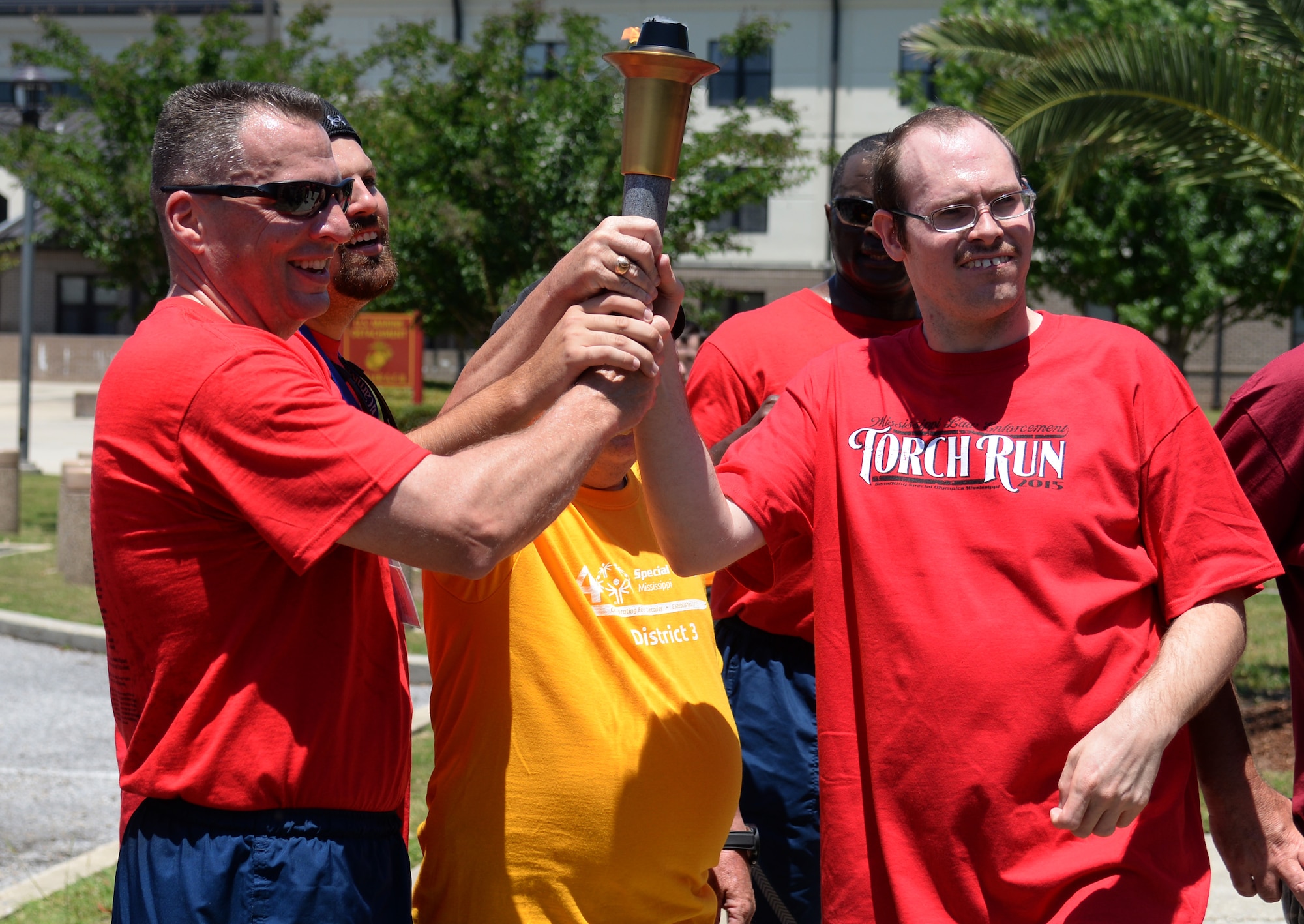 Brig. Gen. Patrick Higby, 81st Training Wing commander, and a Special Olympics athlete hold the Special Olympics Flame of Hope after the 2015 Law Enforcement Torch Run, May 8, 2015, Keesler Air Force Base, Miss. Law enforcement officers from across Mississippi participated in the annual event to escort the torch to the opening ceremonies. (U.S. Air Force photo by Senior Airman Holly Mansfield)