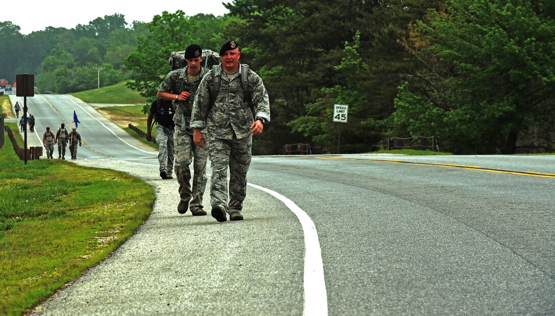 Members of the 11th Security Forces Squadron ruck-march down perimeter road on Joint Base Andrews, Md., May 11, 2015, during National Police Week. Approximately 35 security forces members participated in the ruck-march, where they were required to carry a ruck-sack weighing a minimum of 35 lbs. (U.S. Air Force photo by Senior Airman Mariah Haddenaham/Released)