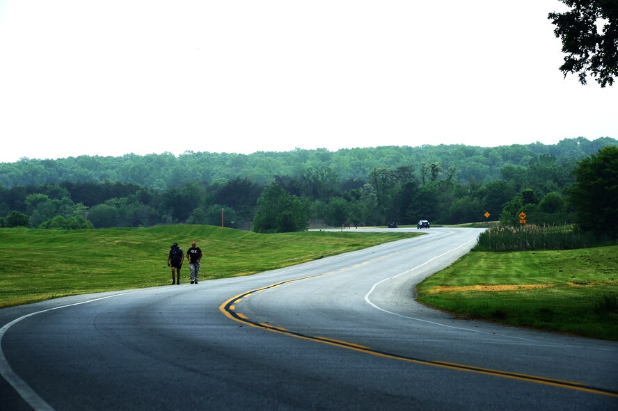 Members of the 11th Security Forces Squadron ruck march down perimeter road on Joint Base Andrews, Md., May 11, 2015, during National Police Week. Approximately 35 security forces members participated in the ruck-march, where they were required to carry a ruck-sack weighing a minimum of 35 lbs. (U.S. Air Force photo by Senior Airman Mariah Haddenaham/Released)