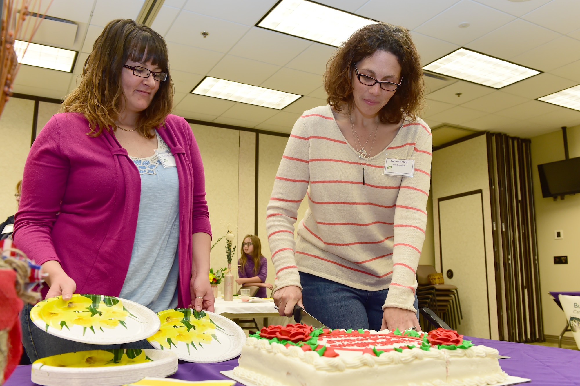 Amanda Miller, Buckley Spouses’ Group Vice President, cuts a cake celebrating the scholarship winners May 9, 2015, on Buckley Air Force Base, Colo. The Spouses’ Group raised and gave away $5,000 in scholarship funds to show support for individuals who are looking to advance through higher education. (U.S. Air Force photo by Airman 1st Class Luke W. Nowakowski/Released)