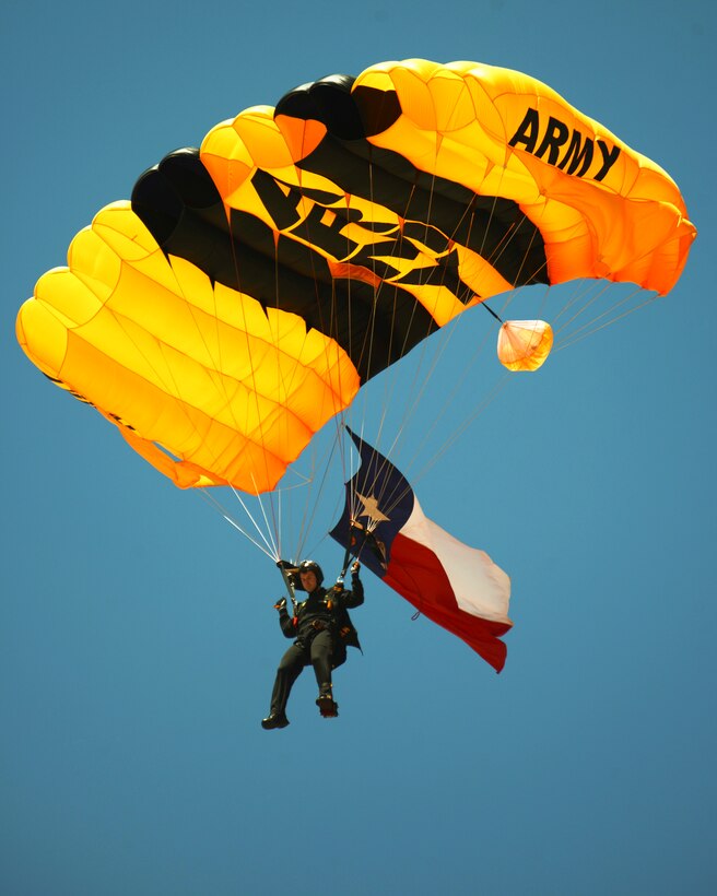 A U.S. Army Golden Knight parachute team member displays the Texas flag during his parachute jump May 3, 2015, at Dyess Air Force Base, Texas. The Golden Knights were one of many performers at the Dyess Big Country Airfest, headlined by the U.S. Air Force Thunderbirds' air demonstration team. (U.S. Air Force photo by Airman 1st Class Kedesha Pennant/Released)