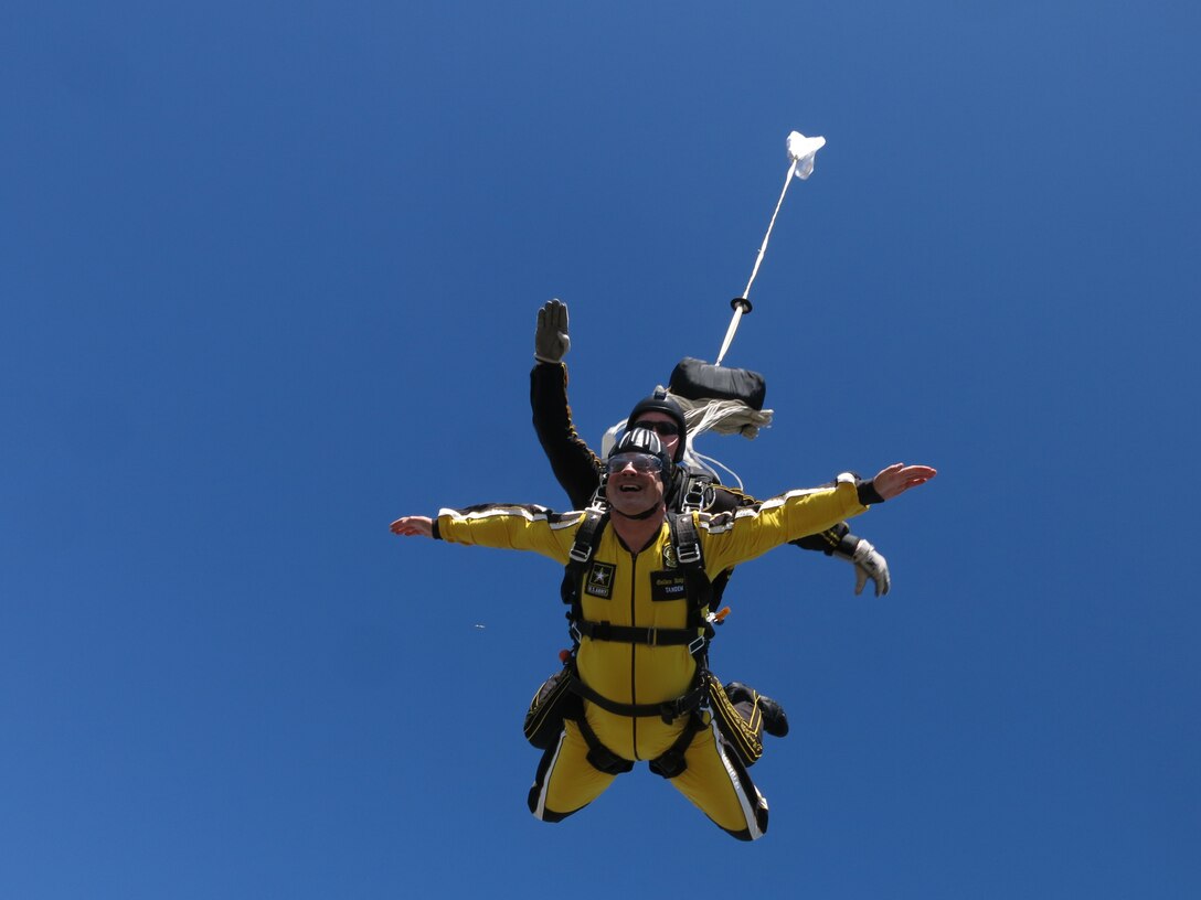 Retired Air Force Master Sgt. Gordon Storey prepares for a parachute to deploy during a tandem jump with the U.S. Army Golden Knights during the opening festivities of Rockin' in the Park May 1, 2015, at Dyess Air Force Base, Texas.  Storey was asked to jump with the Army team after multiple people in the Abilene, Texas, viewing area nominated him to represent the community during a local TV contest. Storey founded and continues to volunteer for the Dyess We Care Team, an organization that provides service work to those in the Big Country area. (U.S. Army photo)