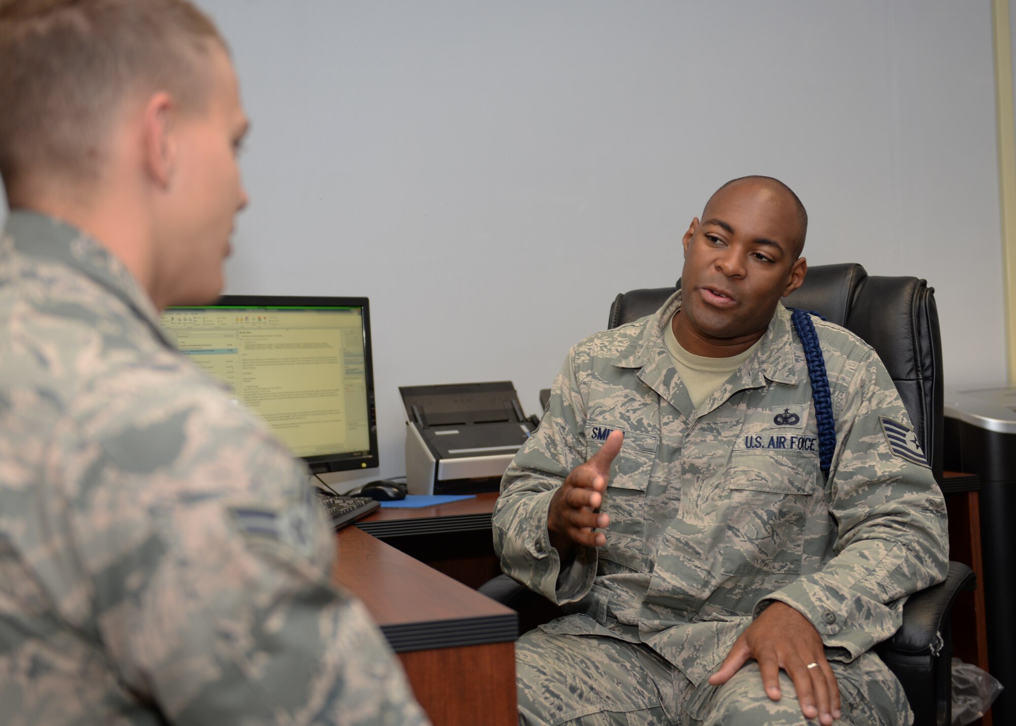 ALTUS AIR FORCE BASE, Okla. – U.S. Air Force Tech. Sgt. Mark Smith, 97th Training Squadron military training leader flight chief, speaks with U.S. Air Force Airman 1st Class Daniel Winkler, boom operator student, in the MTL office May 8, 2015. Military training leaders provide professional development for students. The combined efforts of the military training leaders and the student administration flight ensure Airmen are prepared for training. (Air Force photo by Senior Airman J. Zuriel Lee/Released)