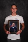 Justin Kovich, son of the 91st Maintenance Group commander, holds his father’s official photo on Minot Air Force Base, N.D.,  May 8, 2015. Justin plans to follow in his father’s footsteps by attending the Air Force Academy to become an officer. (U.S. Air Force photo/Airman 1st Class Christian Sullivan)