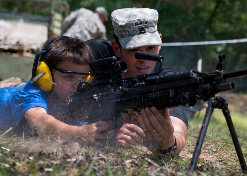 Korey Parker shoots the M240 with the help of a Ranger during the 6th Ranger Training Battalion’s Open House event May 9 at Eglin Air Force Base, Fla. The event was a chance for the public to learn how Rangers train and operate. The event displays showed equipment, weapons, a reptile zoo, face painting and weapon firing among others. The demonstrations showed off hand-to-hand combat, a parachute jump, snake show, and Rangers in action. (U.S. Air Force photo/Tech. Sgt. Jasmin Taylor)