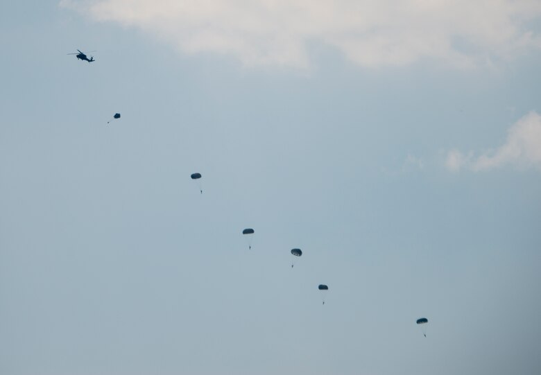 A UH-60 Black Hawk drops six soldiers to show parachute jump procedures during a demonstration at the Rangers’ Open House event May 9 at Eglin Air Force Base, Fla. The event was a chance for the public to learn how Rangers train and operate. The event displays showed equipment, weapons, a reptile zoo, face painting and weapon firing among others. The demonstrations showed off hand-to-hand combat, a parachute jump, snake show, and Rangers in action. (U.S. Air Force photo/Tech. Sgt. Jasmin Taylor)