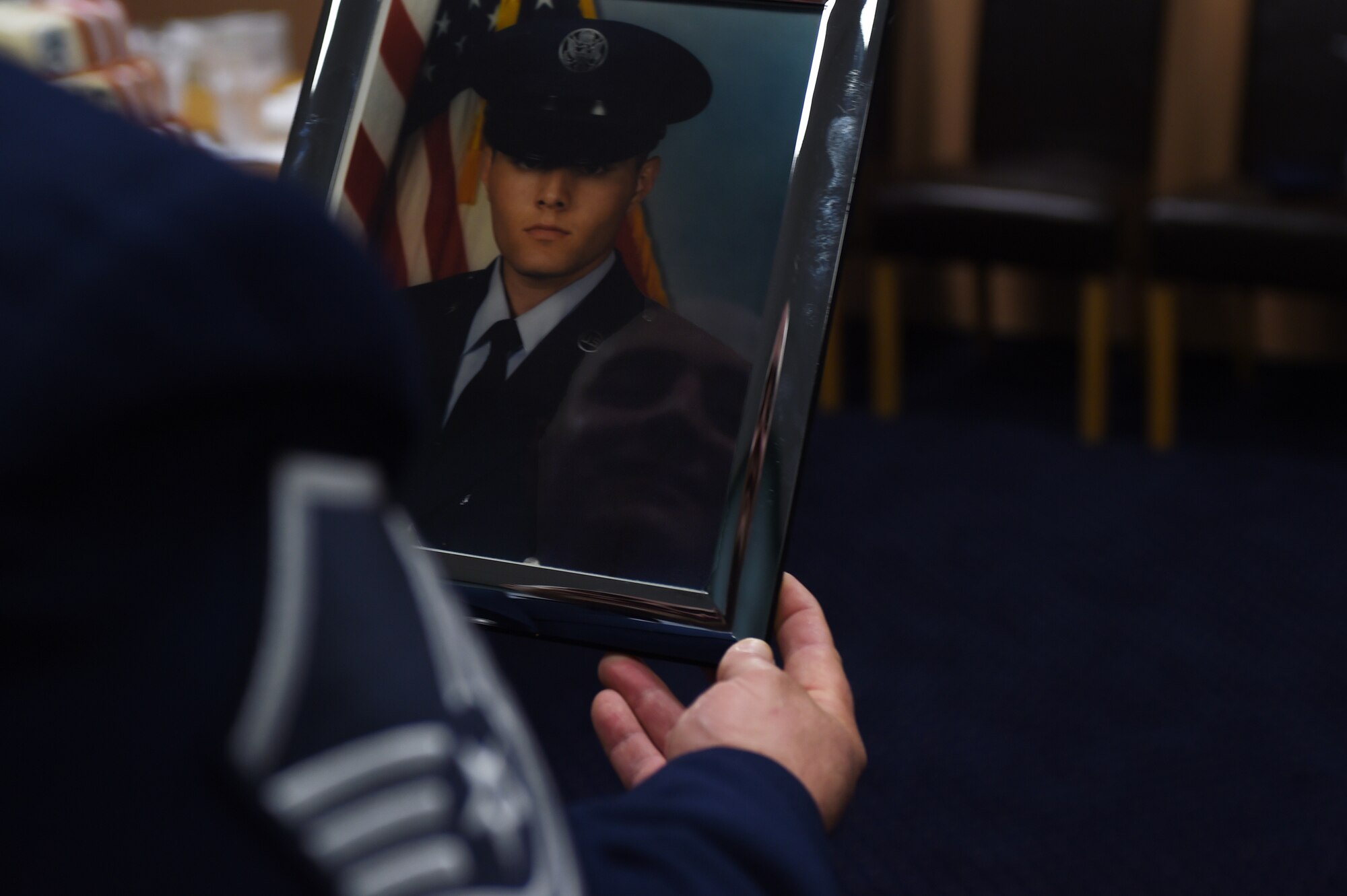Master Sgt. Shawn Leach, 501st Combat Support Wing Emergency Management superintendent, looks at a picture of himself as a young Airman, minutes before his retirement ceremony at RAF Alconbury, England, May 8, 2015. Leach retired from the active duty U.S. Air Force after 23 years of service. (U.S. Air Force photo by Staff Sgt. Jarad A. Denton/Released)