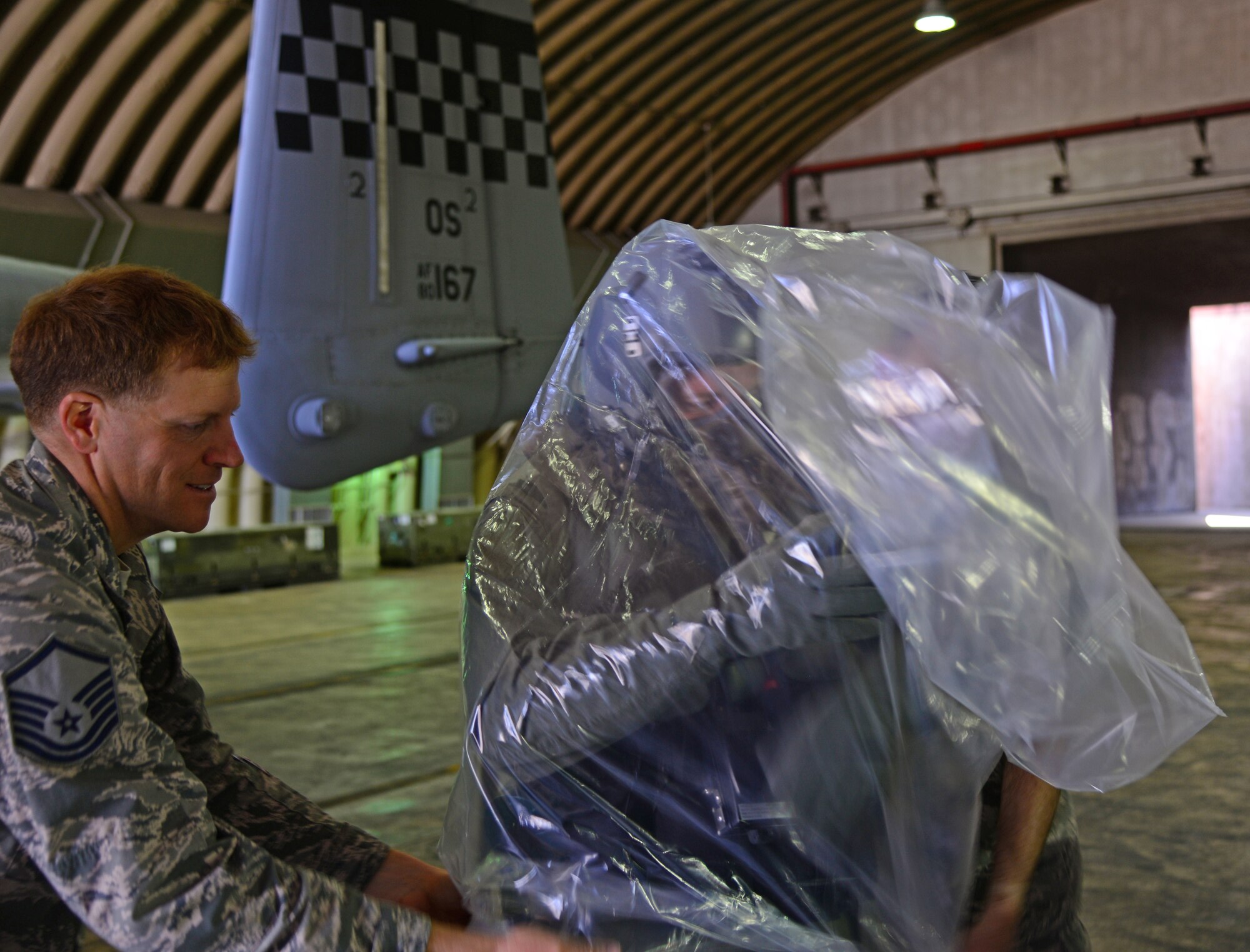 Master Sgt. Ken Rogers, 51st Maintenance Group development and instruction chief, and Master Sgt. Gregory Currey, 51st Operations Support Squadron chief of aircrew flight equipment, assist 1st Lt. Matthew Barrett, 25th Fighter Squadron pilot, with putting on his chemical and biological containment bag May 4, 2015, at Osan Air Base, Republic of Korea. The Team Osan superstars assisted with a training video in preparation for exercise Beverly Midnight 15-02 which is designed to test American forces in the ROK on their mission readiness in the event of an emergency or wartime environment. (U.S. Air Force photo by Staff Sgt. Benjamin Sutton/Released) 