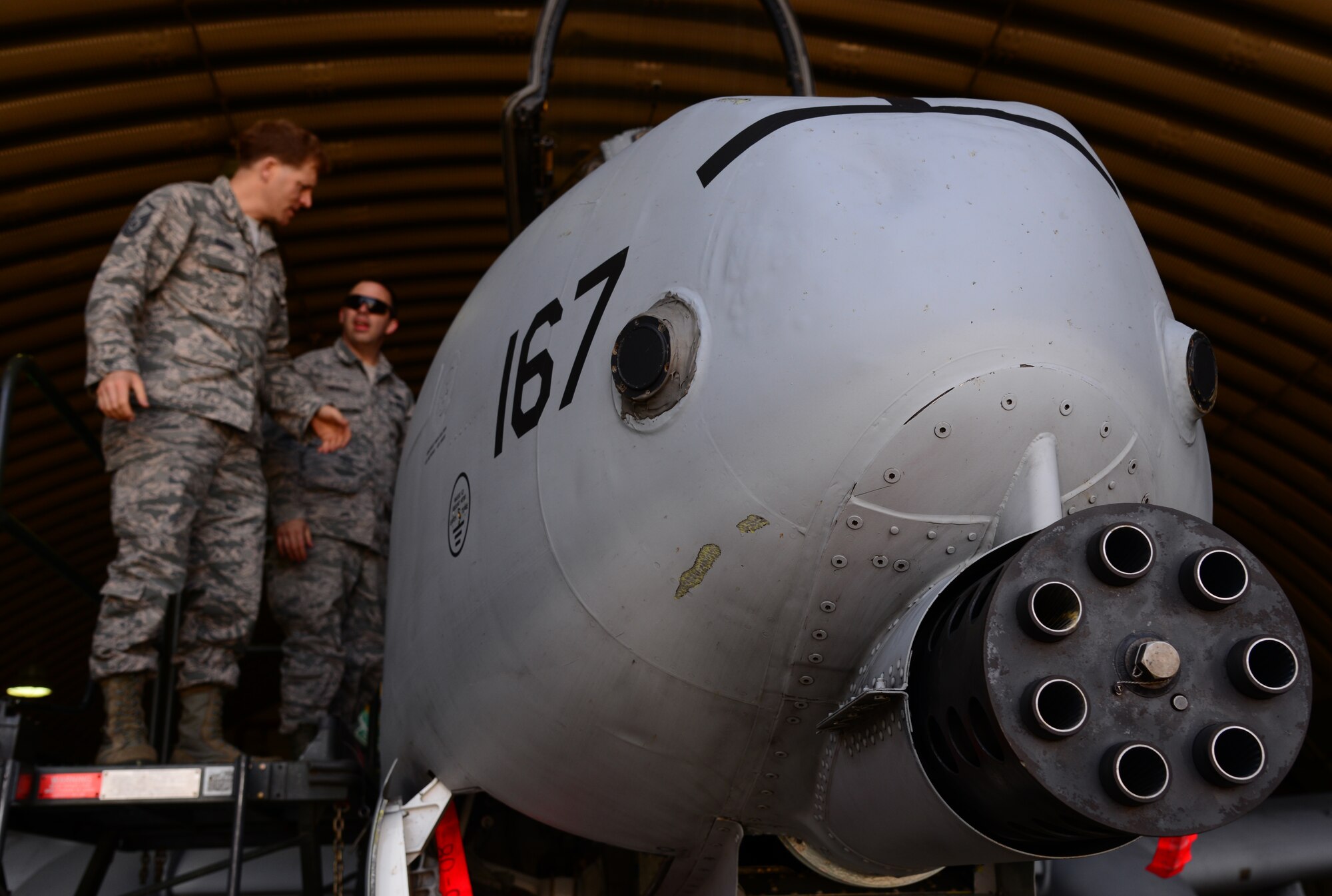 The business end of a GAU-8 Avenger gun is noticeable on the front of an A-10 Thunderbolt II assigned to the 25th Fighter Squadron while Master Sgt. Ken Rogers, 51st Maintenance Group development and instruction chief, and Tech. Sgt. James Menden, 51st MXG aircraft maintenance instructor, discuss training logistics May 4, 2015, at Osan Air Base, Republic of Korea. The Airmen are preparing for the Beverly Midnight 15-02 which is designed to test American forces in the ROK on their mission readiness in the event of an emergency or wartime environment. (U.S. Air Force photo by Staff Sgt. Benjamin Sutton/Released) 