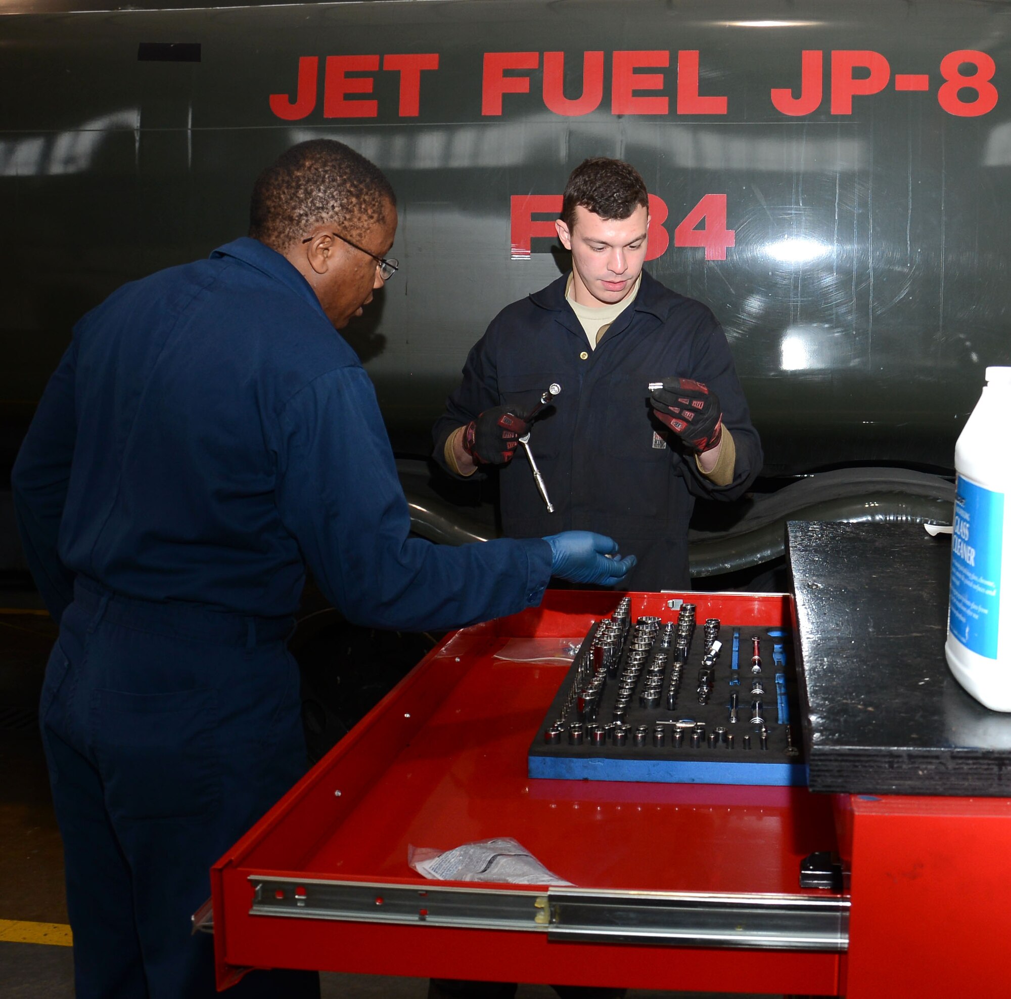 U.S. Air Force Staff Sgt. Peter Mwangi, left, 100th Logistics Readiness Squadron NCO in charge of refueling maintenance from Las Vegas, Nev., and U.S. Air Force Airman 1st Class Jacob Rievel, 100th LRS Refueling Maintenance journeyman from Johnstown, Pa., discuss what tools they will need for maintenance April 23, 2015, on RAF Mildenhall, England. Mwangi and Rievel prepared for maintenance on an R-11 fuels truck that delivers fuel to aircraft and fuels storage facilities on base. (U.S. Air Force photo by Gina Randall/Released)