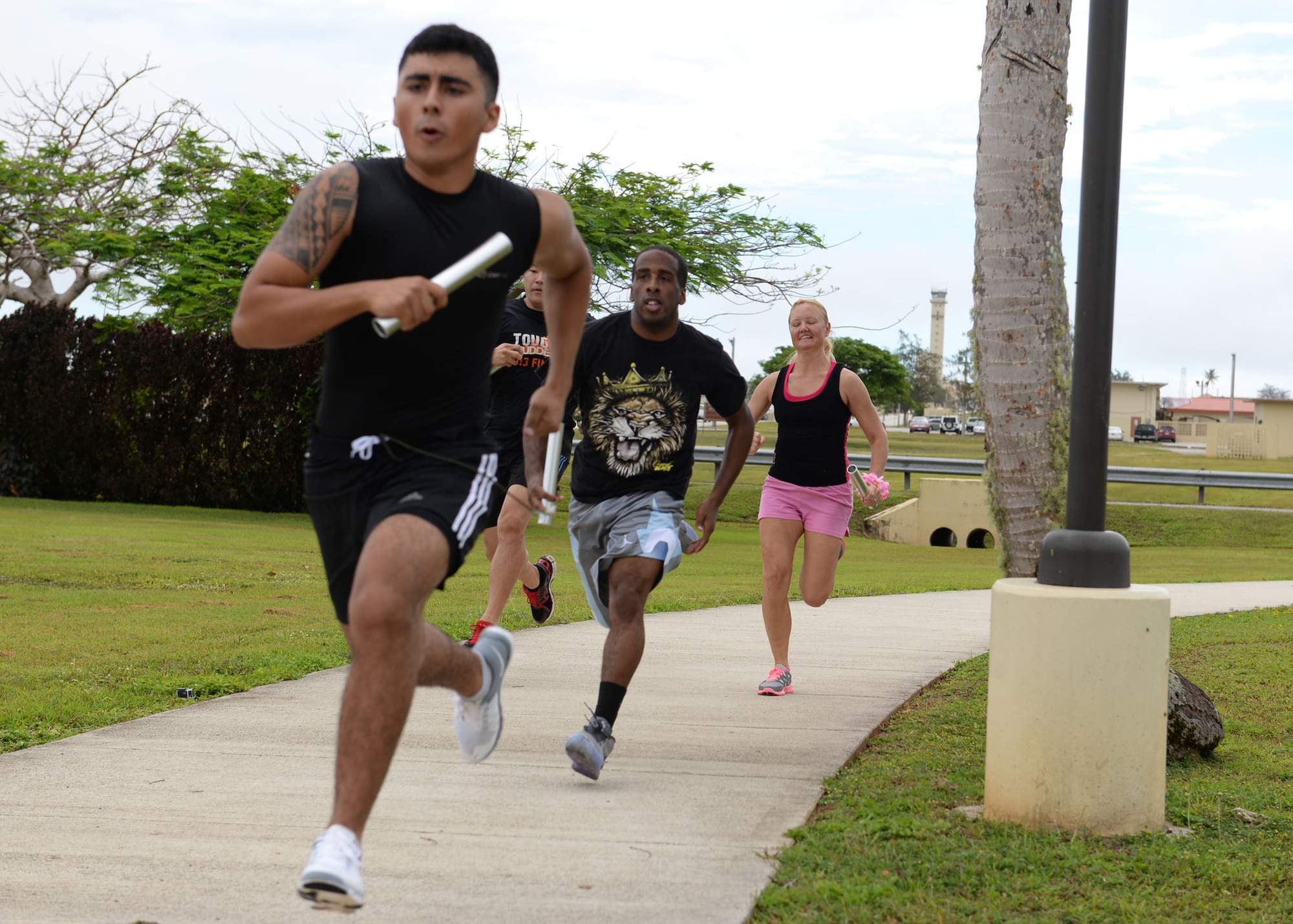 Racers sprint during a baton relay race May 8, 2015, at Arc Light Park, Andersen Air Force Base, Guam. The race was part of the Gladiator Glide, a base-wide morale event held by the Coral Reef Fitness Center, that consisted of several competitions including a baton relay, sack race, wheelbarrow race and a pie eating contest. (U.S. Air Force photo by Airman 1st Class Joshua Smoot/Released)