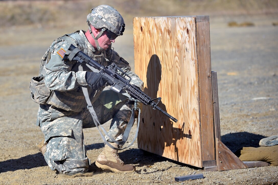 Army Pfc. Randenn Snider kneels at a firing position during a stress shoot event in the Best Warrior competition at Joint Base Elmendorf-Richardson, Alaska, April 28, 2015. Snider is assigned to the 25th Infantry Division's 3rd Battalion, 21st Infantry Regiment, 1st Stryker Brigade Combat Team.