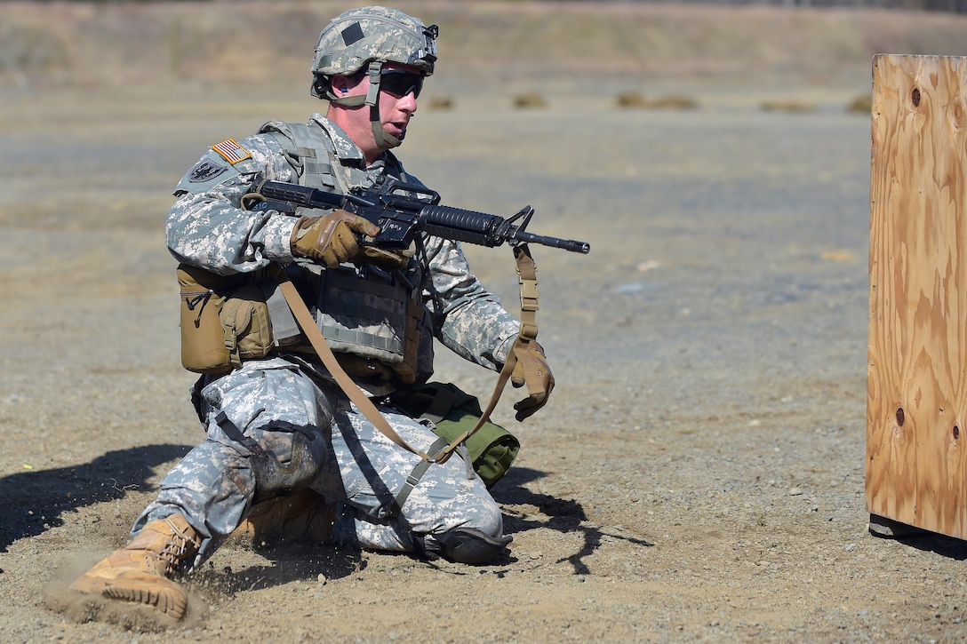Army Cpl. Robert Walker slides into a firing position during a stress shoot event in the Best Warrior competition at Joint Base Elmendorf-Richardson, Alaska, April 28, 2015. Walker is assigned to the 25th Infantry Division's Delta Company, 1st Battalion, 501st Infantry Regiment, 4th Infantry Brigade Combat Team.