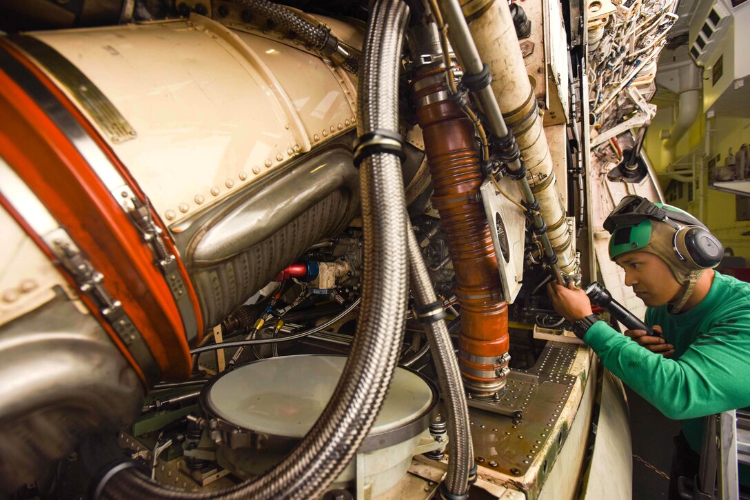U.S. Navy Seaman Christian Velasco removes an engine from an E-2C Hawkeye assigned to Airborne Early Warning Squadron 112 aboard USS John C. Stennis in the Pacific Ocean, April 29, 2015. Velasco is an aviation electrician's mate. 