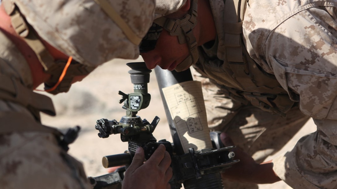 Pfc. Michael Ainsworth, a mortarman with Weapons Company, 3rd Battalion, 5th Marine Regiment adjusts the sights of the 81 mm mortar system during a combined-arms raid at Army National Training Center Fort Irwin, California April 11, 2015. The raid was conducted by 1st Light Armored Reconnaissance Battalion as part of exercise Desert Scimitar 2015.