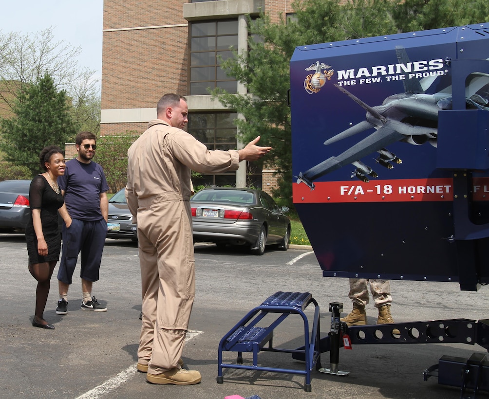U.S. Marine Corps Capt. Richard O’brien an F/A-18 weapons systems officer and the aviation assistant procurement for the eastern recruiting region, Parris Island, South Carolina, shows students from Kent State University the 4th Marine Corps District F/A-18 full-motion flight simulator May 5, 2015.  The Marines bring the simulators to college campuses to build awareness and enthusiasm among students and campus faculty regarding Marine officer programs. (U.S. Marine Corps photo by Cpl. Kyle Welshans/Released)