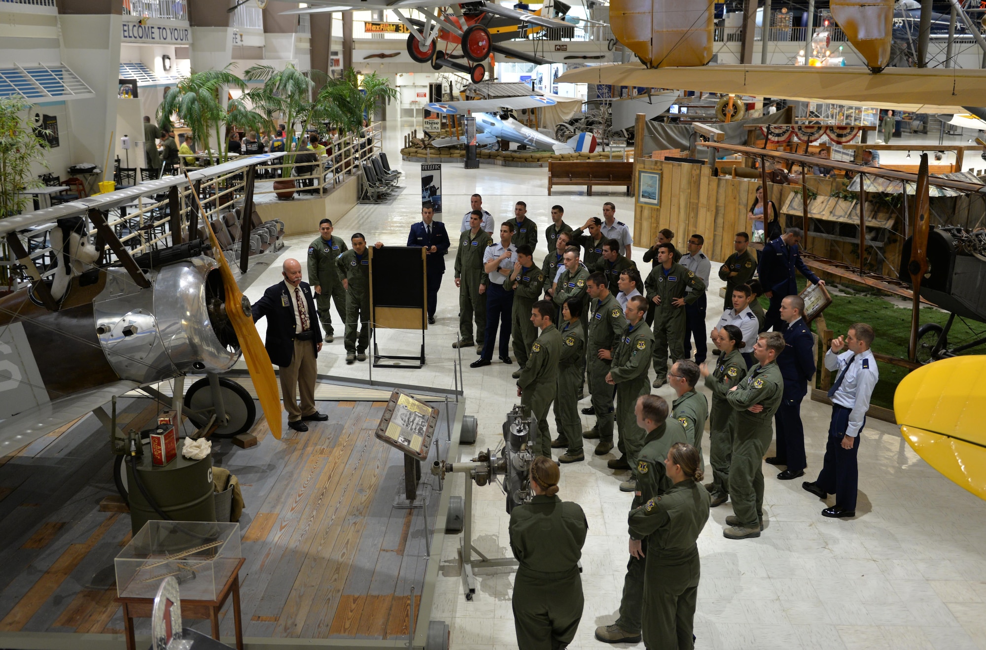 Tim Reuters, former Army helicopter pilot and National Naval Aviation Museum volunteer, guides  451st Flying Training Squadron students  through the museum’s World War I exhibit on Naval Air Station Pensacola May 8, 2015. The students learned about naval aviation history as a part of the Doolittle Raiders celebration. (U.S. Air Force photo/1st Lt. Ben Sowers)