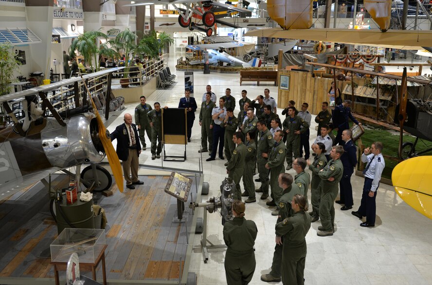 Tim Reuters, former Army helicopter pilot and National Naval Aviation Museum volunteer, guides  451st Flying Training Squadron students  through the museum’s World War I exhibit on Naval Air Station Pensacola May 8, 2015. The students learned about naval aviation history as a part of the Doolittle Raiders celebration. (U.S. Air Force photo/1st Lt. Ben Sowers)
