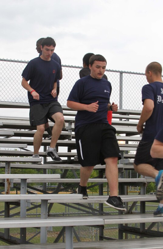 Dylan DeYoung, center, a poolee with Permanent Contact Station Smithfield, runs on bleachers during a physical training session at Smithfield-Selma High School in Smithfield, North Carolina, April 29, 2015. DeYoung lost more than 70 pounds over the course of 17 months to join the Marine Corps. (U.S. Marine Corps photo by Sgt. Dwight A. Henderson/Released)