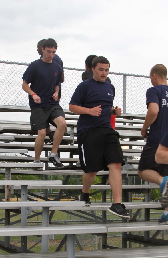 Dylan DeYoung, center, a poolee with Permanent Contact Station Smithfield, runs on bleachers during a physical training session at Smithfield-Selma High School in Smithfield, North Carolina, April 29, 2015. DeYoung lost more than 70 pounds over the course of 17 months to join the Marine Corps. (U.S. Marine Corps photo by Sgt. Dwight A. Henderson/Released)