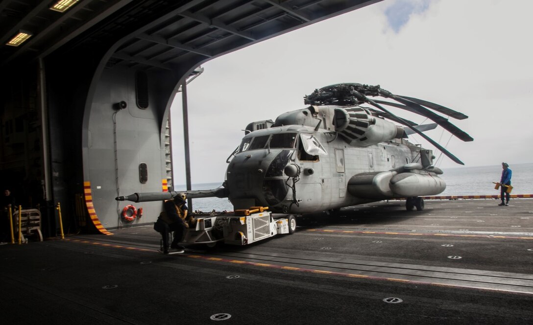 U.S. Navy Sailors with the Essex Amphibious Ready Group guide a CH-53E Sea Stallion into the hangar bay of the USS Essex (LHD 2) off the coast of San Diego, May 11, 2015. The Marines and Sailors of the 15th Marine Expeditionary Unit and ESSEX ARG were departing for a  seven-month deployment. (U.S. Marine Corps photo by Cpl. Elize McKelvey/Released)