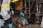 A member of the 24th Civil Support Team from the New York National Guard takes an air sample in a simulated clandistine weapons lab during the unit's validation exercise on June 8, 2010.