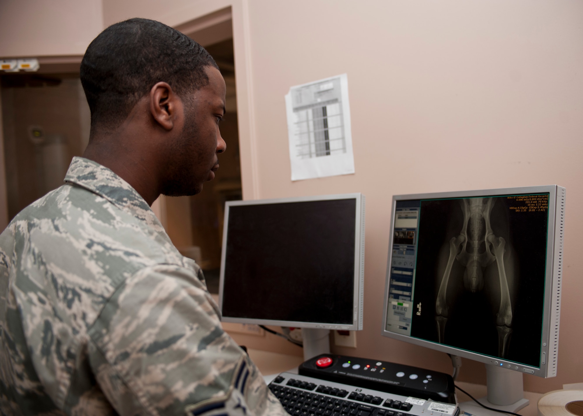 Airman 1st Class Devon Ross, 99th Medical Surgical Operations Squadron technician, looks over an X-ray of a military working dog at Nellis Air Force Base, Nev., May 1, 2015. On average, the Diagnostic Imaging Clinic sees 60,000 patients a year and more than 150 patients a day. (U.S. Air Force photo by Airman 1st Class Jake Carter)