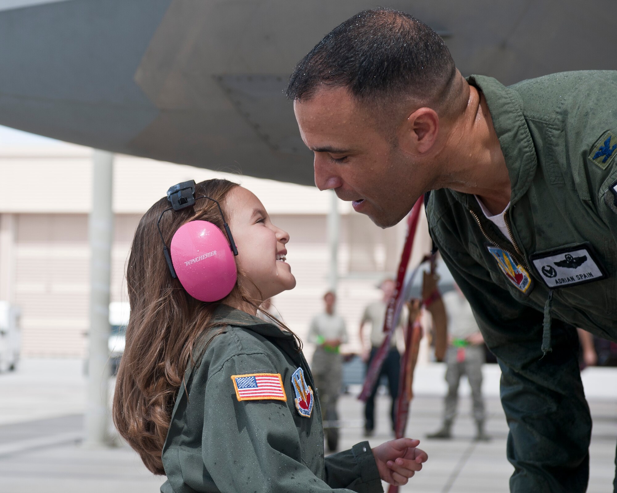 Col. Adrian Spain, U.S. Air Force Weapons School commandant, attempts to kiss his daughter after his final flight as the USAFWS commandant at Nellis Air Force Base, Nev., May 11, 2015. Spain’s family was on hand to congratulate the outgoing USAFWS commandant on a successful tour at Nellis AFB. (U.S. Air Force photo by Staff Sgt. Siuta B. Ika)
