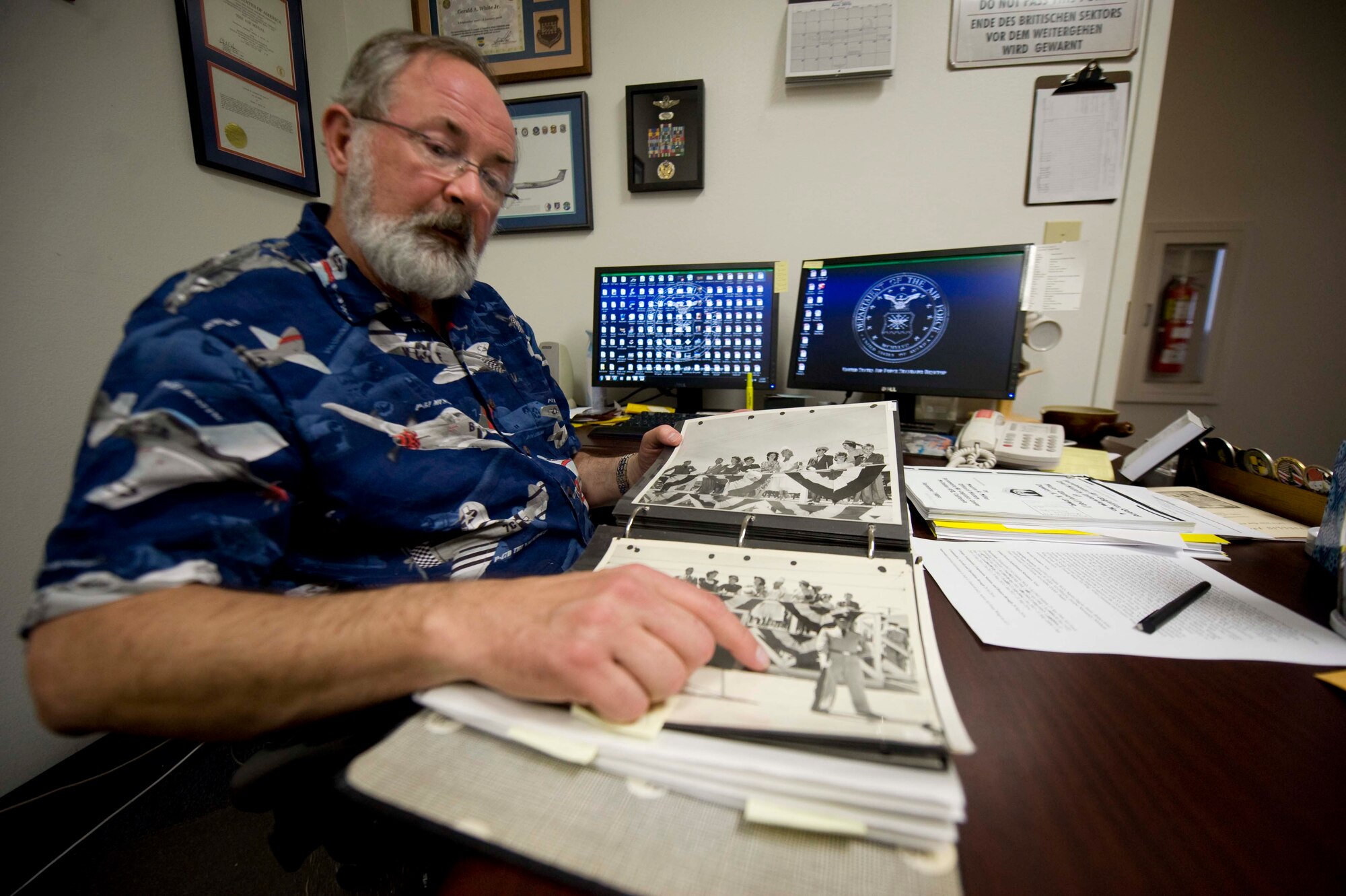 Gerald White, 99th Air Base Wing historian, looks over historical photos at Nellis Air Force Base Nev., May 1, 2015. White acts as an archiver of major events that have occurred on Nellis AFB since its inception in 1935. (U.S. Air Force photo by Airman 1st Class Rachel Loftis)  