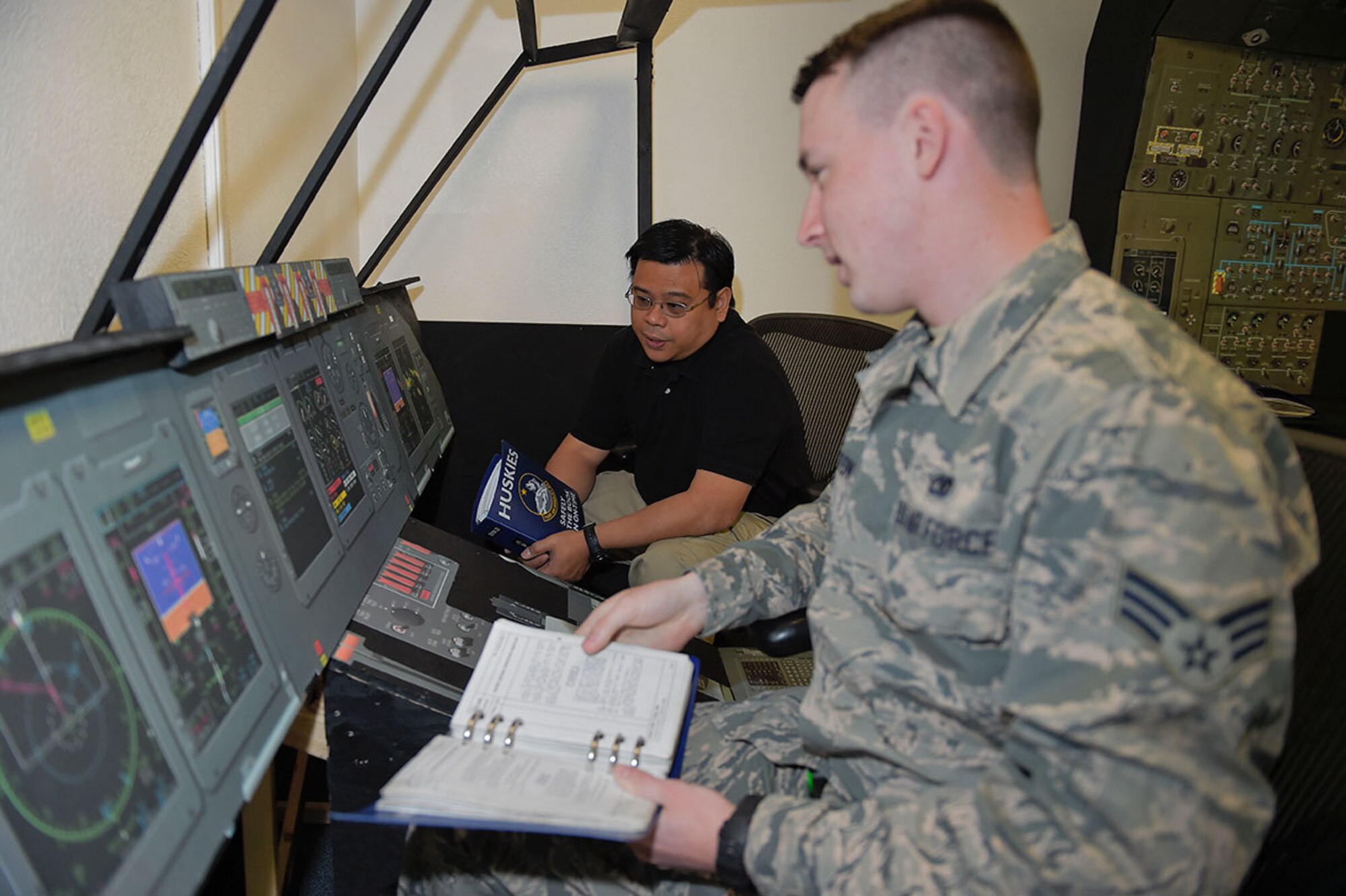 Jolly Tangog, an equipment specialist with Air Force engineering and technical services for the 732nd Air Mobility Squadron, supervises Senior Airman Adam Orton, a jets lead technician, as he uses a C-5M Super Galaxy maintenance trainer on Joint Base Elmendorf-Richardson, Alaska, May 7, 2015. Tangog came up with the cost-saving idea to build a trainer at JBER rather than sending Airmen away on a temporary duty for expensive refresher training. (U.S. Air Force photo/Alejandro Pena)