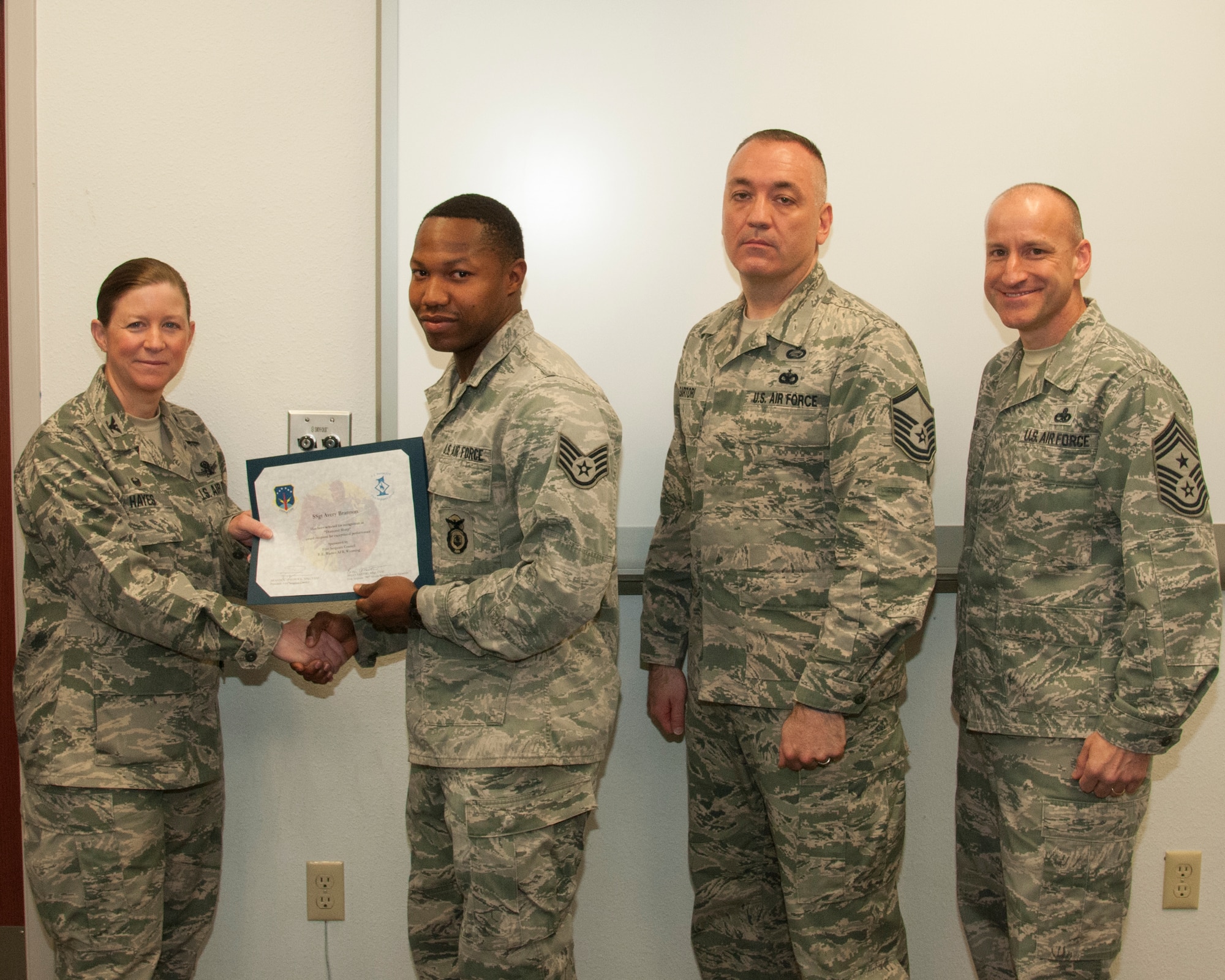 Staff Sgt. Avery Brannon, 790th Missile Security Forces Squadron Tactical Response Force, poses with Col. Tracey Hayes, 90th Missile Wing commander; Master Sgt. Brian Sartori, 790th MSFS first sergeant; and Chief Master Sgt. Samuel Couch, 90th MW command chief, during the wing's first sergeants' Diamond Sharp Award presentation May 12, 2015, on F.E. Warren Air Force Base, Wyo. First sergeants nominate an Airman in their respective squadrons for the award, and the first sergeants select the three top contenders for the award each month. (U.S. Air Force photo by Senior Airman Jason Wiese)