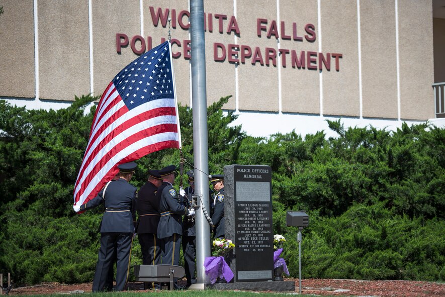 Wichita Falls, Texas, police officers raise the U.S. and Texas flags during a Police Week ceremony at the Wichita Falls police department, May 11, 2015. During the raising of the flags, TAPS was played in respect for officers who lost their lives in the line of duty. Former President John F. Kennedy proclaimed May 15 as National Peace Officers Memorial Day and the week it falls in as National Police Week. (U.S. Air Force photo by Senior Airman Kyle Gese/Released) 