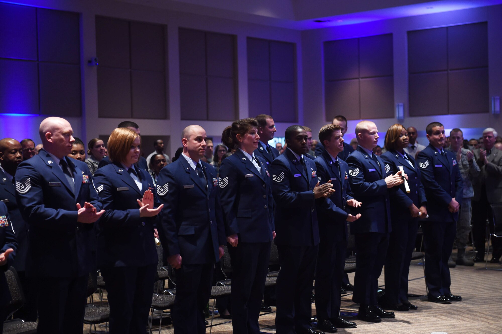 31 Team Buckley members stand during the Community College of the Air Force graduation ceremony May 12, 2015, at the Leadership Development Center on Buckley Air Force Base, Colo. Graduates received various Associates in Applied Sciences degrees. CCAF is the only degree-granting institution in the world open exclusively to enlisted members. (U.S. Air Force photo by Airman First Class Samantha Meadors/Released)