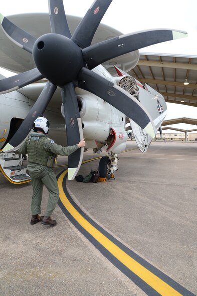 Lt. Cmdr. Eddy Depuy, Naval Aviator assigned to the Seahawks of Carrier Airborne Early Warning Squadron, VAW-126, Norfolk, Virginia, inspects the propeller on an E-2C Hawkeye prior to departure at Barksdale Air Force Base, Louisiana, April 22, 2015. Pilots inspect the aircraft internally and externally with assistance from mechanics to ensure the safety of the aircrew during take-off, flight and landing. (U.S. Air Force photo/Senior Airman Joseph A. Pagán Jr.)