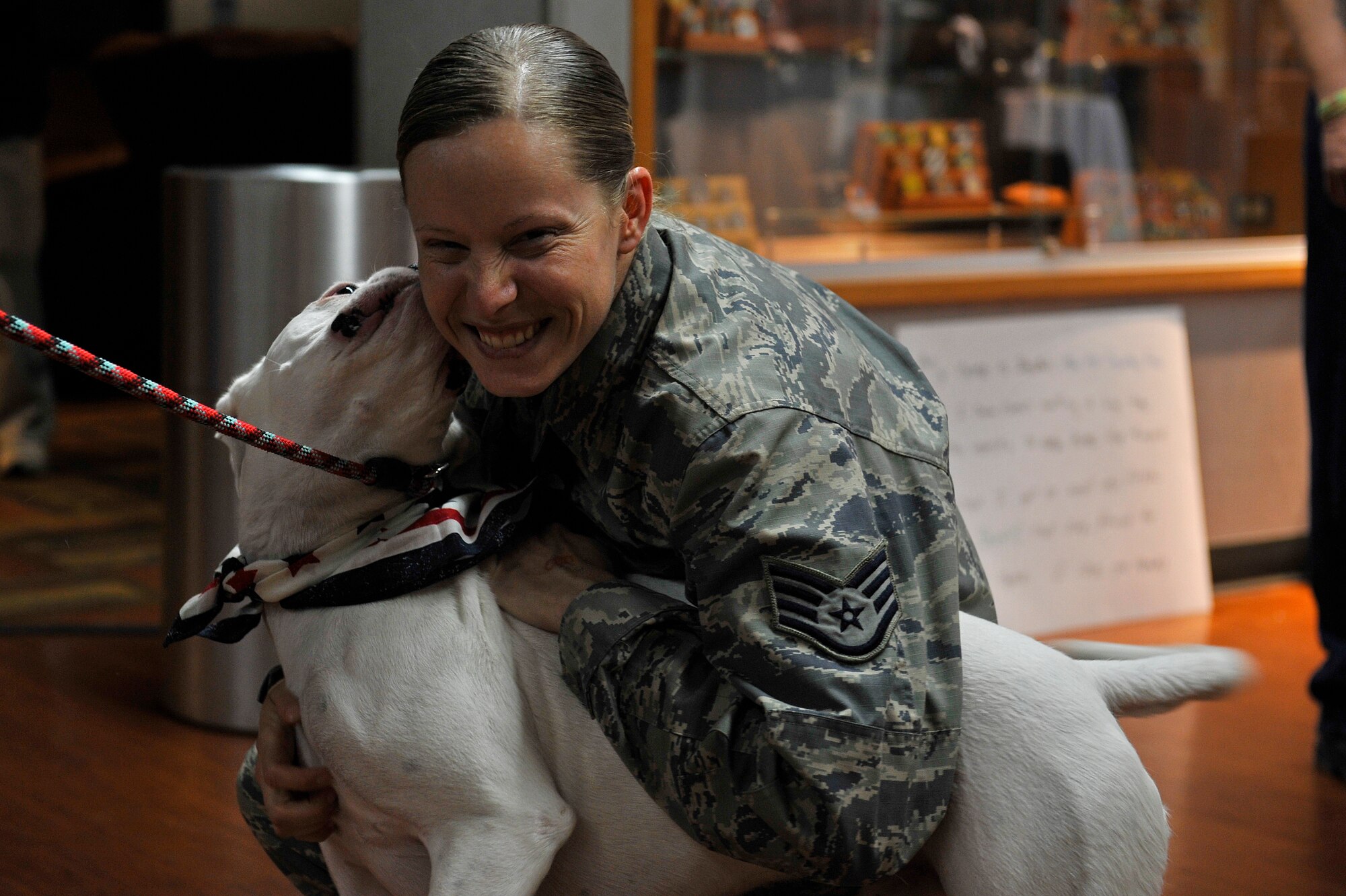 Staff Sgt. Arin Vickers, 435 Supply Chain Operations Squadron, spends time with her dog Baxter, that she just reunited with at the St. Louis Airport USO, St. Louis, Missouri, May 6, 2015. Vickers was gone for 6 months, and her friends and family were there to greet her and surprise her with Baxter. Vickers and Baxter would later welcome their new family member, a dog named Bandit, who Vickers rescued from Kuwait, where she was deployed. (U.S. Air Force photo by Airman 1st Class Erica Crossen)