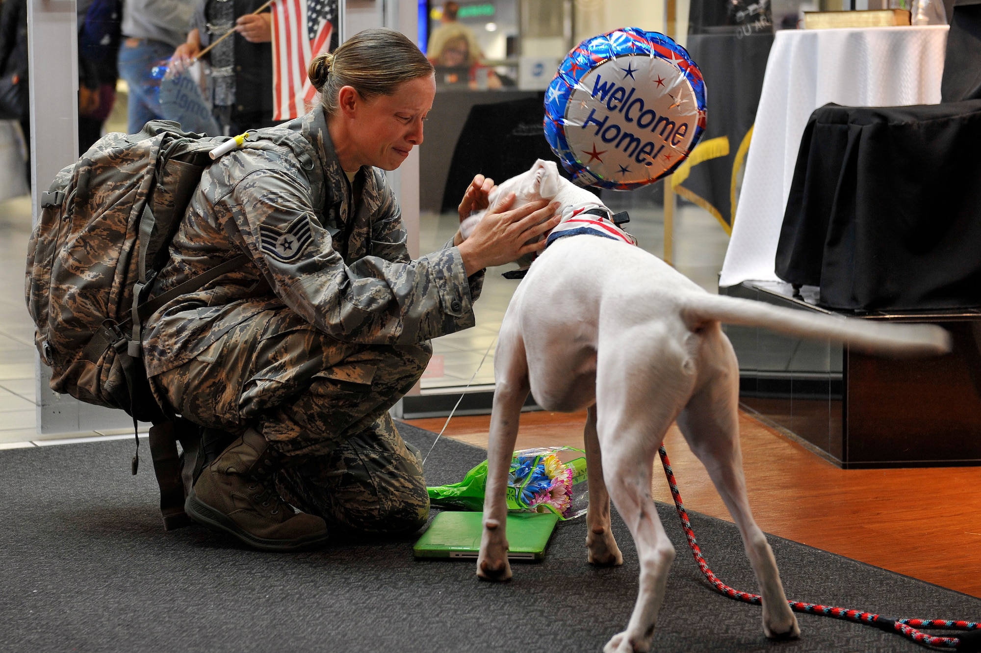 Staff Sgt. Arin Vickers, 435 Supply Chain Operations Squadron, is surprised by her dog when she arrives at the St. Louis Airport USO, St. Louis, Missouri, May 6, 2015. Vickers was gone for 6 months, and her friends and family were there to greet her and surprise her with Baxter. Vickers and Baxter would later welcome their new family member, a dog named Bandit, who Vickers rescued from Kuwait, where she was deployed. (U.S. Air Force photo by Airman 1st Class Erica Crossen)