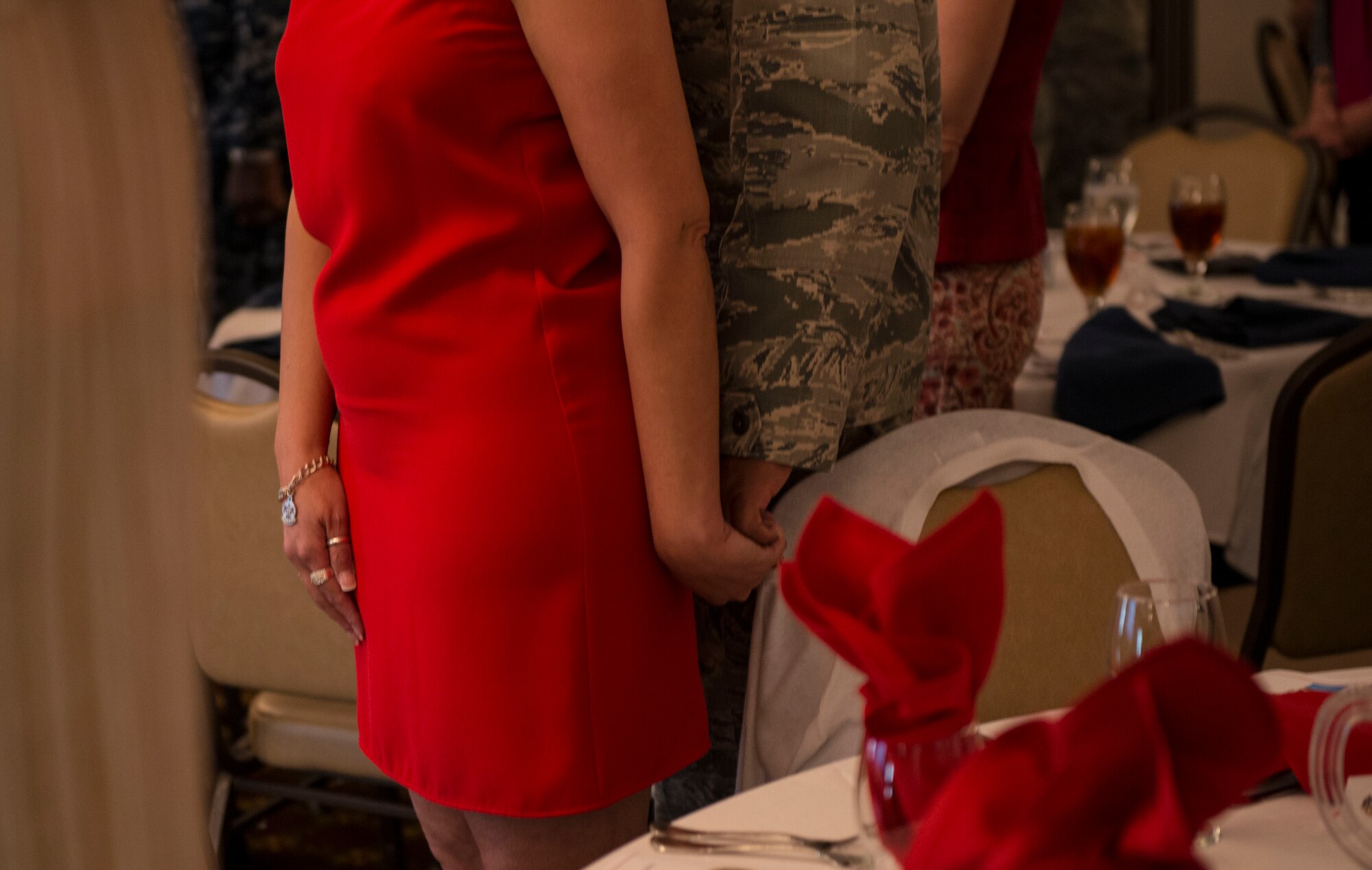A service member and his wife hold hands during a prayer at the annual Spouses Appreciation Day Luncheon on Joint Base McGuire-Dix-Lakehurst, N.J. May 8, 2015. The luncheon gave an opportunity for services members to express gratitude for sacrifices made by their spouses. (U.S. Air Force photo by Airman 1st Class Joshua King)