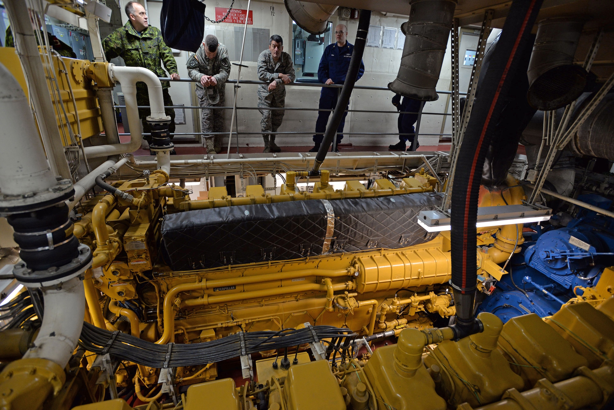 COAST GUARD BASE KODIAK, Alaska — U.S. Coast Guard Petty Officer 1st Class Kendall Cook, USCG Buoy Tender SPAR machinery technician (middle right), explains the vessel’s engine capabilities and performance to attendees of the General Officer/Flag Officer conference April 30. Alaskan Command and U.S. Coast Guard’s District 17 hosted the Arctic GO/FO Conference April 29 – May 1, which included flag officers from the U.S. Air Force, U.S. Army, U.S. Coast Guard, Alaska National Guard and Canadian Forces, to strengthen partnerships, discuss future Arctic and Alaskan challenges and joint capabilities. (U.S. Air Force photo/Tech. Sgt. John Gordinier)