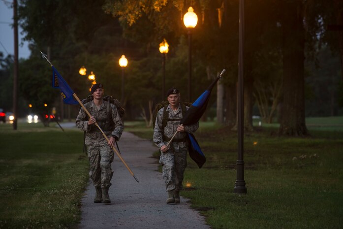 Airman 1st Class Hunter Dudley and Lt. Col. Warren Brainard, 628th Security Forces Squadron commander, march with the squadron guidon and the “Thin Blue Line” flag May 12, 2015 at Joint Base Charleston, S.C., during a 24-hour ruck march.  The event to honor police officers killed in the line of duty was held as part of the 2015 National Police Week celebration. The ‘Thin Blue Line’ represents the sacrifices made by those who protect and serve. Events for this year’s police week include a picnic, a 24-hour ruck march, a golf tournament, a chili cook-off, motorcycle ride and a retreat ceremony.  (U.S. Air Force photo/Senior Airman Jared Trimarchi) 
