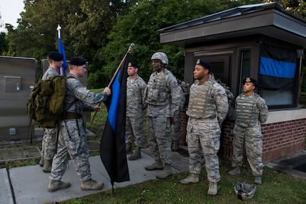Lt. Col. Warren Brainard, 628th Security Forces Squadron commander, hands off the Thin Blue Line flag to the next group of participants May 12, 2015 at Joint Base Charleston, S.C., during a 24-hour ruck march.  The event to honor police officers killed in the line of duty was held as part of the 2015 National Police Week celebration. The ‘Thin Blue Line’ represents the sacrifices made by those who protect and serve. Events for this year’s police week include a picnic, a 24-hour ruck march, a golf tournament, a chili cook-off, motorcycle ride and a retreat ceremony.  (U.S. Air Force photo/Senior Airman Jared Trimarchi) 