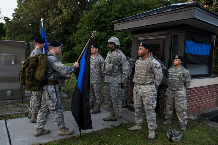 Lt. Col. Warren Brainard, 628th Security Forces Squadron commander, hands off the Thin Blue Line flag to the next group of participants May 12, 2015 at Joint Base Charleston, S.C., during a 24-hour ruck march.  The event to honor police officers killed in the line of duty was held as part of the 2015 National Police Week celebration. The ‘Thin Blue Line’ represents the sacrifices made by those who protect and serve. Events for this year’s police week include a picnic, a 24-hour ruck march, a golf tournament, a chili cook-off, motorcycle ride and a retreat ceremony.  (U.S. Air Force photo/Senior Airman Jared Trimarchi) 