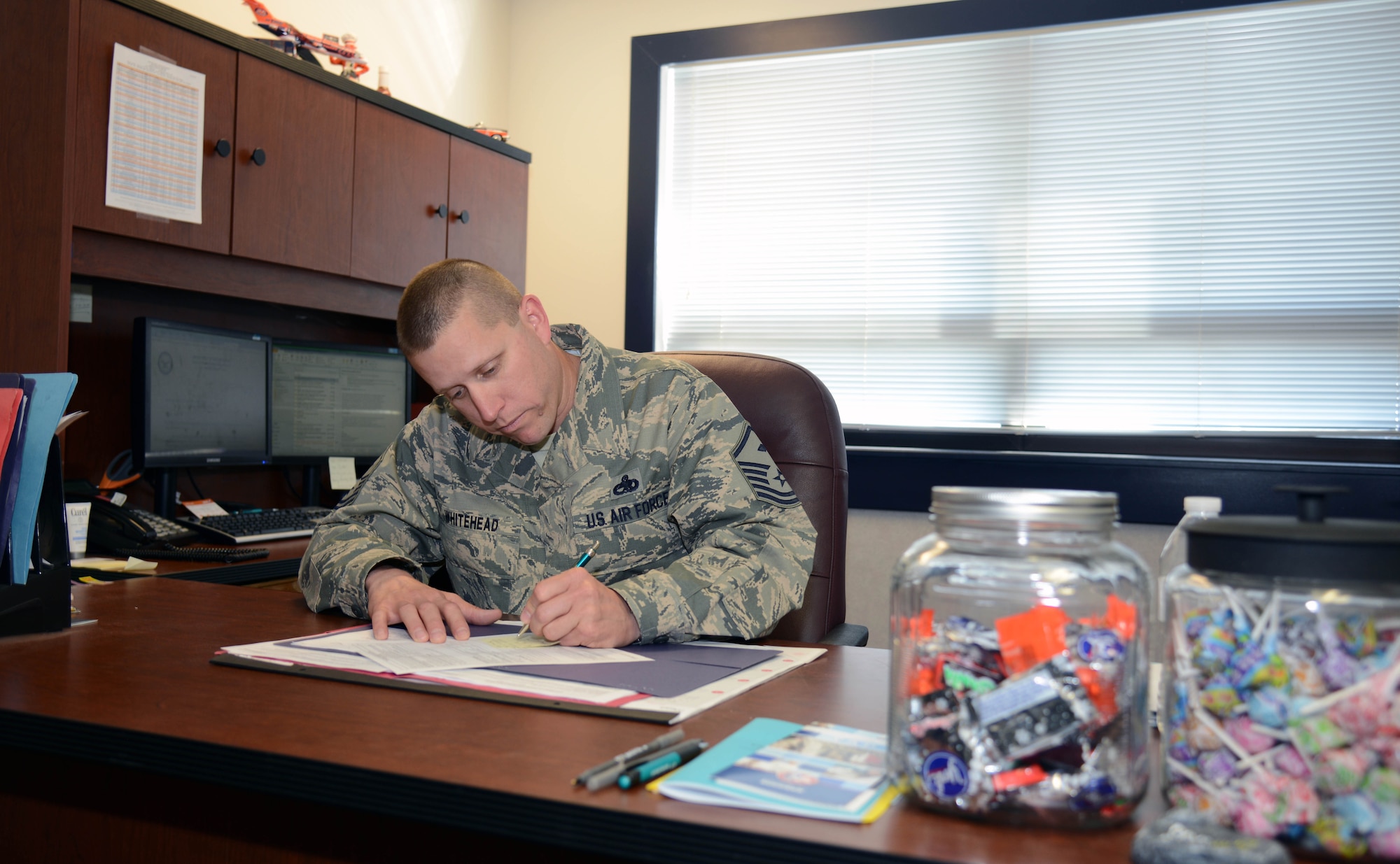 Master Sgt. Jason Whitehead, 341st Security Forces Squadron first sergeant, completes paperwork in his office May 5, 2015, at Malmstrom Air Force Base, Mont. His duties are split between administrative work and being actively involved in Airmen’s lives. (U.S. Air Force photo/ Airman 1st Class Dillon Johnston)