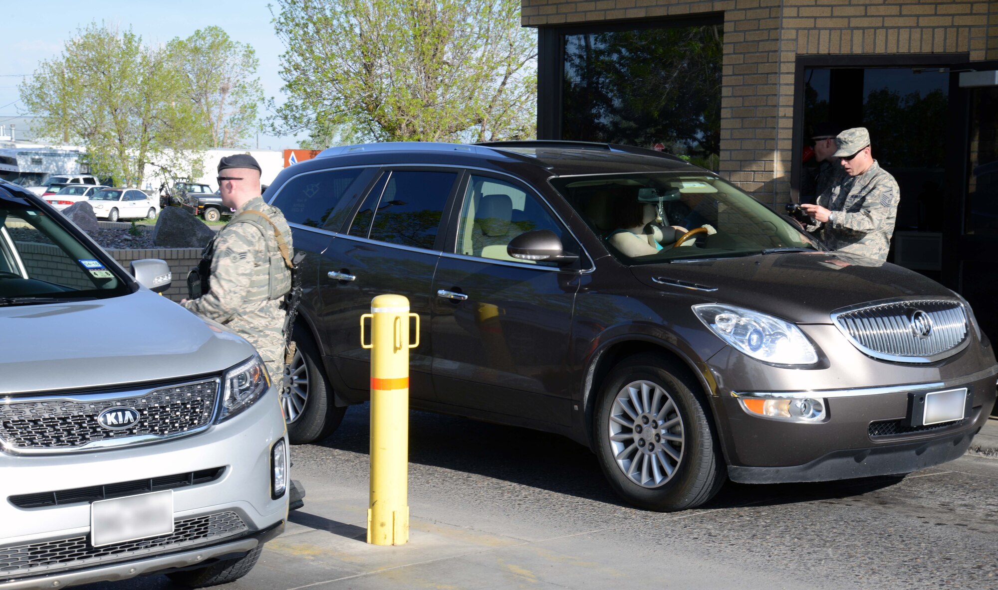 Master Sgt. Jason Whitehead, right, 341st Security Forces Squadron first sergeant, checks identification cards at the front gate May 5, 2015, at Malmstrom Air Force Base, Mont. Whitehead enjoys being in the same environment as his Airmen to get a better understanding of their everyday lives. (U.S. Air Force photo/ Airman 1st Class Dillon Johnston)