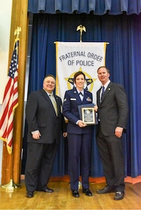 Senior Airman Catherine Lund, a base defense operation center controller from the 628th Security Forces Squadron, receives the Award of Valor from members of the Tri-County Fraternal Order of Police Lodge #3 April 23, 2015, at Charleston, S.C. Lund was the first responder to a major vehicle accident June 9, 2014 on Aviation Avenue near Joint Base Charleston, S.C. Lund is the first military member to receive the award. (Courtesy photo) 