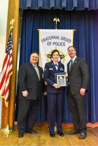 Senior Airman Catherine Lund, a base defense operation center controller from the 628th Security Forces Squadron, receives the Award of Valor from members of the Tri-County Fraternal Order of Police Lodge #3 April 23, 2015, at Charleston, S.C. Lund was the first responder to a major vehicle accident June 9, 2014 on Aviation Avenue near Joint Base Charleston, S.C. Lund is the first military member to receive the award. (Courtesy photo) 