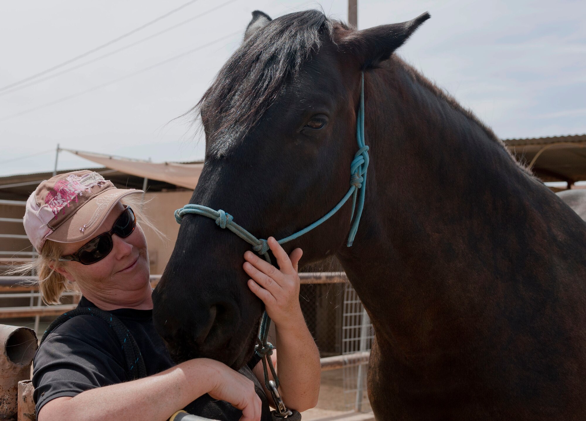 Chanel Jernigan, wife of retired Master Sgt. Stacy Jernigan, pets her horse Zuli at the stables on Nellis Air Force Base, Nev., May 6, 2015. Jernigan brought Zuli back to the United States from Italy. (U.S. Air Force photo by Airman 1st Class Mikaley Towle)