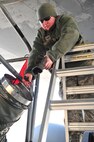 Senior Airman Kasey Castor, 5th Maintenance Group weapons load crew team member, warms her hands while performing maintenance on a B-52H Stratofortress on Minot Air Force Base, N.D., Jan. 30, 2015. Castor has been in the Air Force for six years and enjoys the pride she receives from being a weapons-loader. (U.S. Air Force photo/Senior Airman Malia Jenkins)